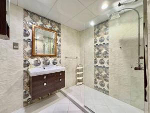a bathroom with a sink and a shower with a mirror at AR Holiday Home JBR 2 in Dubai