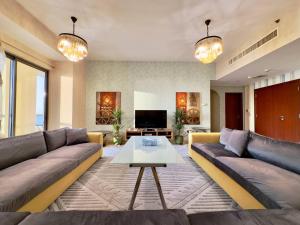 a living room with a couch and a table at AR Holiday Home JBR 2 in Dubai