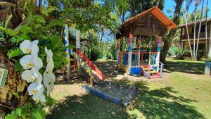 un parque infantil en un patio con una estructura de juegos en Hotel e Pousada Canto Mágico, en Maresias