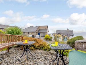 a patio with two tables and a bench at 3 Bed in Harlech 42153 in Harlech
