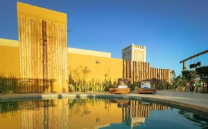 a building with a pool of water and a clock tower at Volantes do Sertão - Ecoville in Piranhas