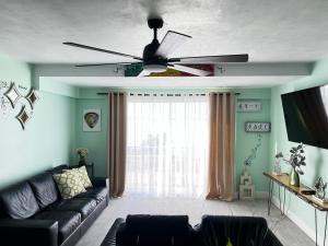 sala de estar con sofá y ventilador de techo en SEAFLECTIONS en Kingston