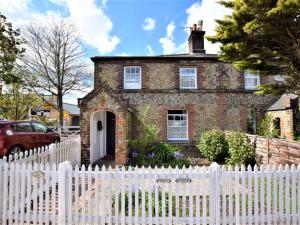 une clôture blanche devant une maison en briques dans l'établissement 1 Bed in Wymondham 43278, à Wymondham