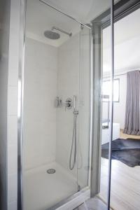 a shower with a glass door in a bathroom at Arles Hideaway - Le Duplex des Arènes in Arles