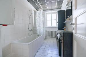 a white bathroom with a tub and a sink at Große 4-Zimmer-Wohnung in der Ingolstädter City. in Ingolstadt