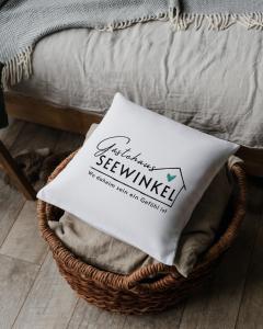 ein Korb mit Handtüchern neben einem Bett in der Unterkunft Gästehaus Seewinkel in Presseggersee