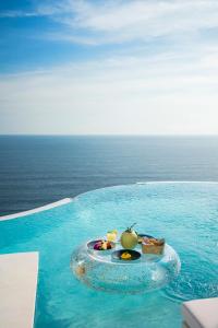 a plate of food on a tray in a swimming pool at Private Jet Villa Uluwatu in Uluwatu