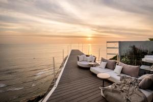 a deck with two couches and a view of the ocean at Private Jet Villa Uluwatu in Uluwatu