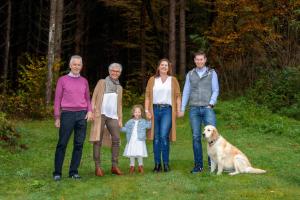 a family posing for a picture with a dog at Gästehaus Seewinkel in Presseggersee