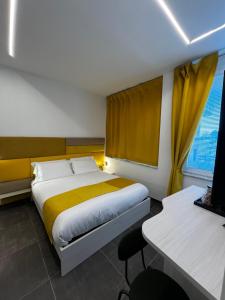 a hotel room with a bed and a desk and a window at Joyfül Accomodation in Finale Ligure