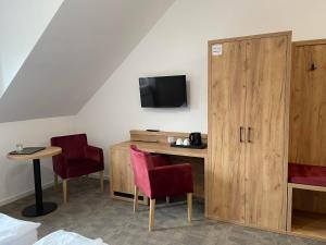 a room with a desk and two chairs and a tv at Centrum Turystyki Wiejskiej Alicja in Księżpol