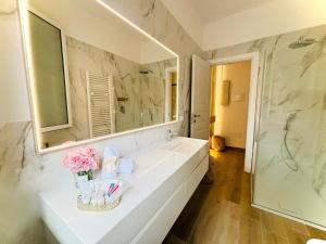 a bathroom with a sink and a large mirror at Sant'Orsola Lodge Bologna in Bologna