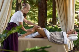 a woman giving a man a knee massage at Ostrova Spa Hotel in Sochi