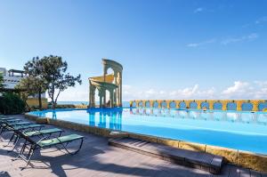 een zwembad in een resort met stoelen bij Ostrova Spa Hotel in Sotsji