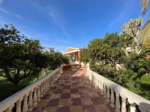uma passagem que leva a um edifício com árvores em Tiguimi Vacances - Oasis Villas, cadre naturel et vue montagne em Agadir