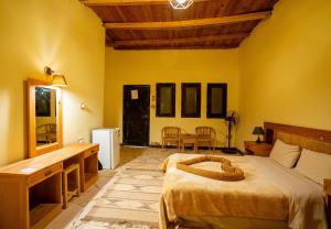 une chambre avec un lit, un bureau et une table dans l'établissement Dehiba Siwa Resort, à Siwa