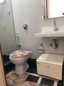 a bathroom with a toilet and a sink at gaivotas com ar condicionado in Guarapari