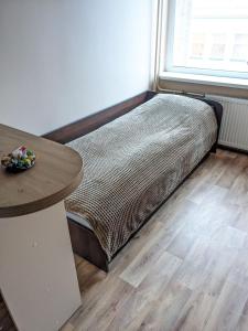 a small bed in a room with a table at Studio apartment at Cozy Apartments in Kaunas