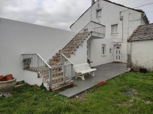 Casa blanca con escalera y banco en BARBEITE, en Barreiros