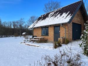 eine Blockhütte mit einem Picknicktisch im Schnee in der Unterkunft Cottage with Seaview in Holbæk