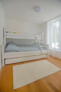 białe łóżko piętrowe w pokoju z dywanem w obiekcie Bjelasnica view lodge w mieście Bjelašnica