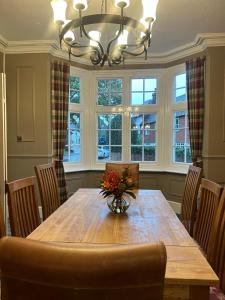 a dining room table with a vase of flowers on it at The Ardingly Inn in Ardingly