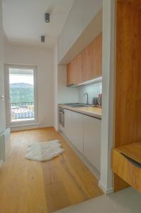 a kitchen with white cabinets and a wooden floor at Bjelasnica view lodge in Bjelašnica