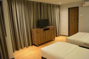 a hotel room with two beds and a flat screen tv at Go Hotel in Subang Jaya