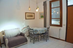 a living room with a table and a chair at Appartamento Sant'Omobono in Cremona