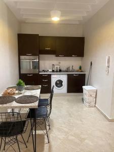 a kitchen with a table and chairs and a washer at Peaceful Apartment: Hivernage,Guéliz in Marrakesh