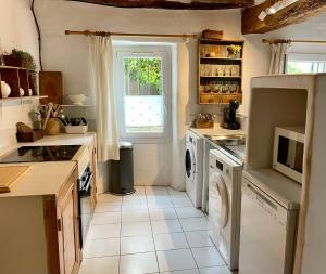 a kitchen with a washing machine and a window at Chez Fanny in Bédoin