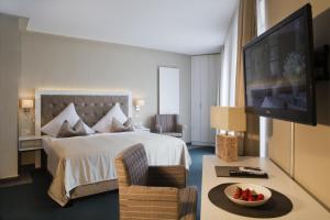 ウッカーミュンデにあるHafenHotel PommernYachtのベッドとテレビが備わるホテルルームです。