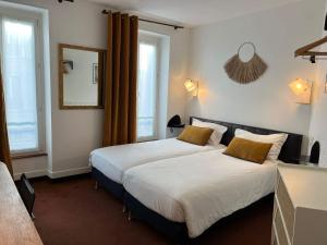 een slaapkamer met een groot wit bed met gele kussens bij Best Western Aramis Saint Germain in Parijs