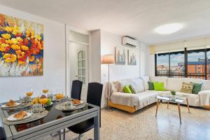 a living room with a table and a couch at LUMINOSO APARTAMENTO/ 5 MINUTOS DE LA PLAYA in Málaga