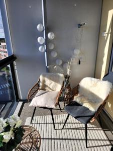 einen Balkon mit zwei Stühlen und Kissen darauf in der Unterkunft Tasokas 2 h + k + s Söderkullassa - huikeat näköalat in Sipoo