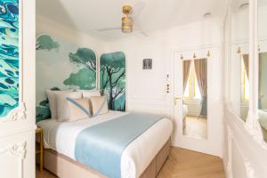 Schlafzimmer mit einem Bett mit blauen und weißen Wänden in der Unterkunft Luxury 4 Bedroom & 3 Bathroom Apartment - Louvre in Paris