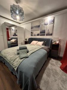 a bedroom with a large bed and a chandelier at MEBA APARTMENTS in Braşov