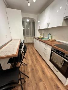 a kitchen with white cabinets and a table with chairs at MEBA APARTMENTS in Braşov +6 photos