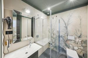 a bathroom with a shower and a sink and a mirror at Villa Erizio, Bordeaux Centre in Bordeaux
