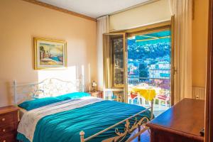 a bedroom with a bed and a table and a window at MARI E MONTI Appartamento centrale con vista panoramica in Rapallo