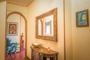 een kamer met een spiegel en een houten tafel bij [MARI E MONTI] Appartamento in centro in Rapallo