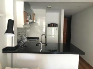 uma cozinha com um lavatório e um frigorífico em Loft con piscina en Punta Carretas em Montevidéu