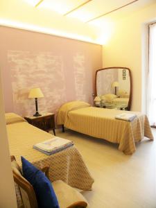 ペルージャにあるAl Ponte Vecchioのベッド2台と鏡が備わるホテルルームです。