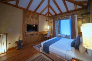 A bed or beds in a room at Sarangkot Mountain Lodge