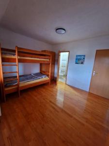 a room with two bunk beds and a wooden floor at Snowman Apartments in Kupres