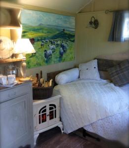 a bedroom with a bed with a painting on the wall at Beech shepherds hut in York