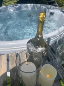 a bottle of champagne and candles next to a swimming pool at Beech shepherds hut in York