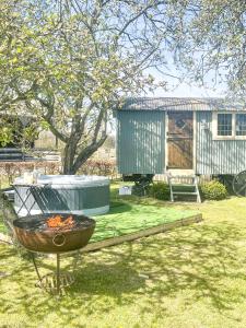 a fire pit in a yard with a building at Beech shepherds hut in York