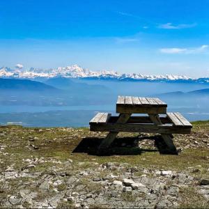 a picnic table sitting on top of a hill overlooking the water at Nice and cosy flat near Geneva or Annecy in Bellegarde-sur-Valserine