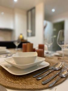 a white bowl and spoon on a wooden table at Nice and cosy flat near Geneva or Annecy in Bellegarde-sur-Valserine